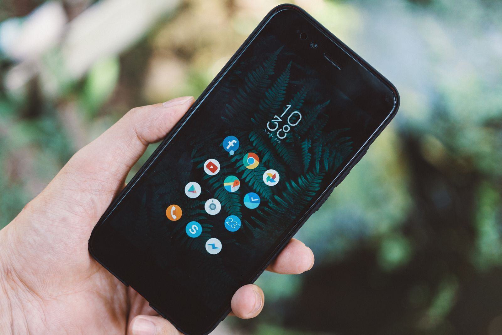 Mão segurando um smartphone Android com vários aplicativos na tela